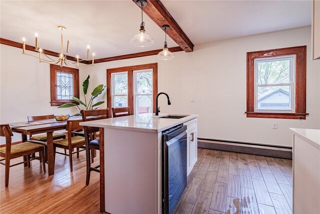kitchen featuring dishwashing machine, a sink, a baseboard heating unit, light wood-type flooring, and healthy amount of natural light