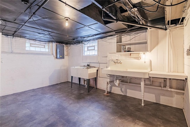 basement featuring electric panel and a sink