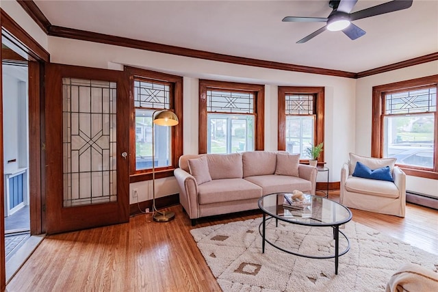 living room with wood finished floors, baseboards, crown molding, and ceiling fan