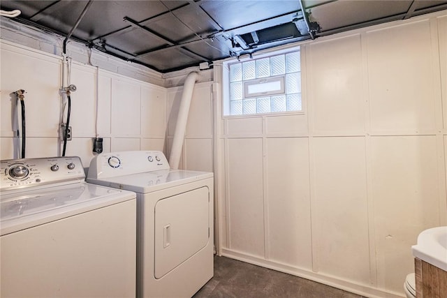 laundry room featuring separate washer and dryer and a decorative wall
