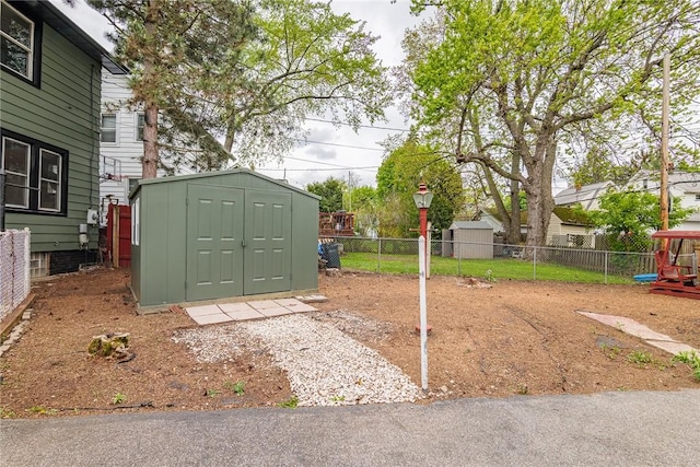 view of yard with a storage unit, an outbuilding, and fence