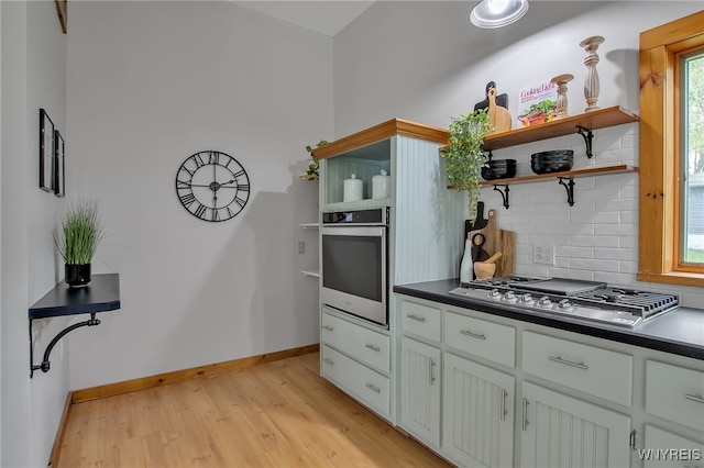 9466 Ridge Rd, Hartland, NY 14105 - kitchen featuring stainless steel appliances, open shelves, dark countertops, light wood-style flooring, and backsplash