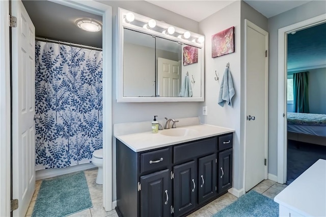 bathroom featuring vanity, toilet, tile patterned flooring, and connected bathroom