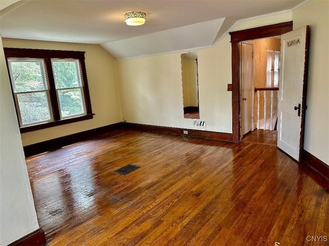additional living space featuring vaulted ceiling, hardwood / wood-style flooring, and baseboards