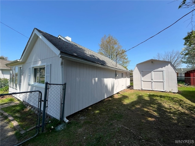 1597 Franklin St, Newfane, NY 14126 - view of side of property featuring a storage unit, an outbuilding, a shingled roof, and a chimney