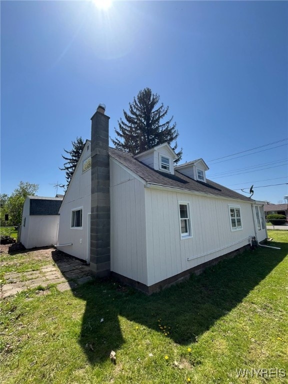 1597 Franklin St, Newfane, NY 14126 - view of side of home featuring a lawn and a chimney