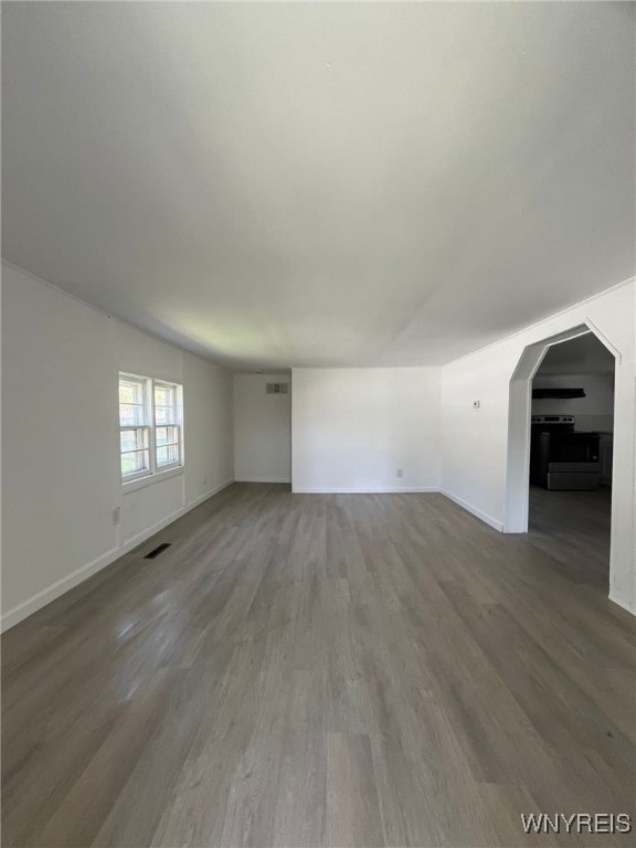 1597 Franklin St, Newfane, NY 14126 - unfurnished living room with wood finished floors, baseboards, and arched walkways