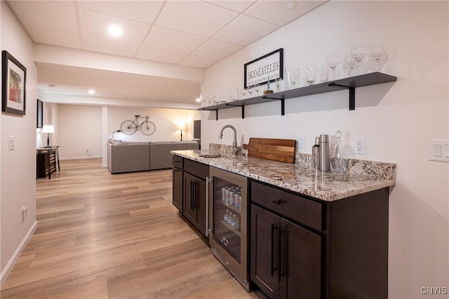 4490 Lauder Ln, Skaneateles, NY 13152 - indoor wet bar featuring beverage cooler, a paneled ceiling, light wood-style floors, and baseboards