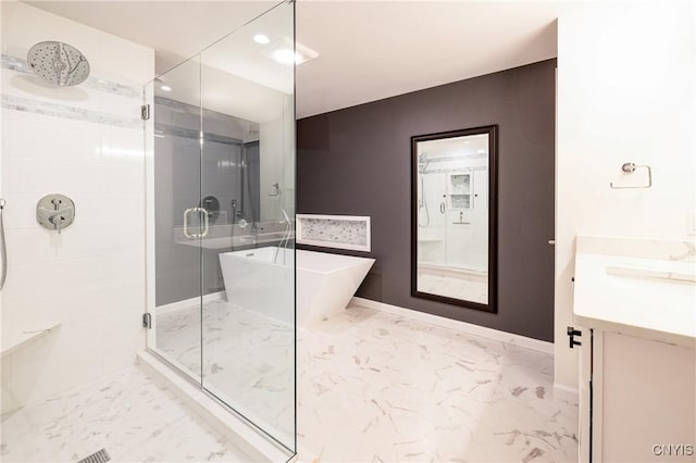 4490 Lauder Ln, Skaneateles, NY 13152 - full bath with marble look tile flooring, a shower stall, a soaking tub, baseboards, and vanity
