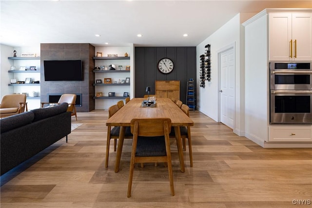4490 Lauder Ln, Skaneateles, NY 13152 - dining room with light wood-style flooring, a fireplace, recessed lighting, and built in shelves