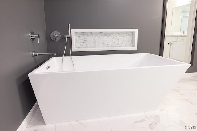 4490 Lauder Ln, Skaneateles, NY 13152 - bathroom featuring marble look tile flooring, vanity, a freestanding tub, and baseboards