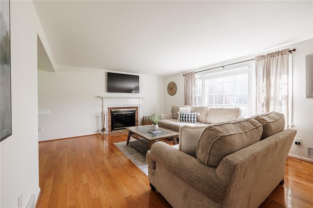 living room featuring a fireplace and light wood-style flooring
