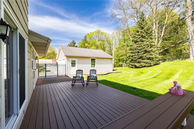 wooden terrace featuring a yard and an outdoor structure