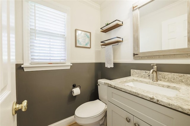 half bathroom featuring toilet, crown molding, and vanity