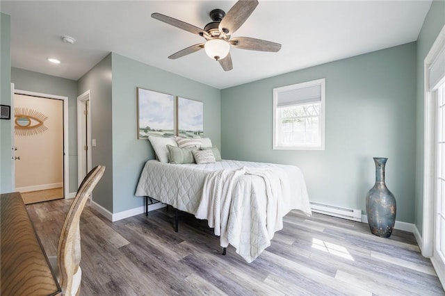 bedroom featuring baseboard heating, wood finished floors, baseboards, a ceiling fan, and recessed lighting