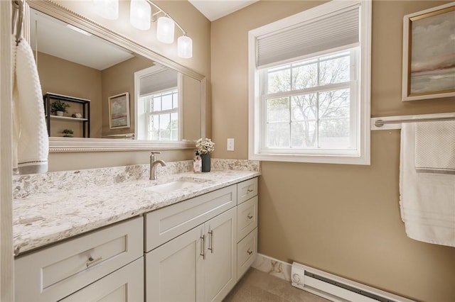 bathroom featuring a baseboard heating unit, vanity, and baseboards