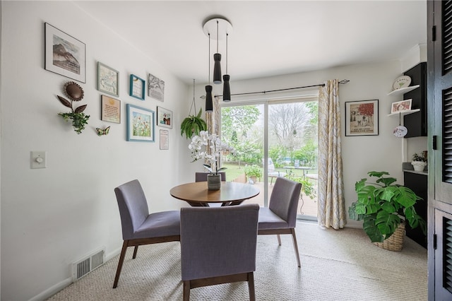 carpeted dining room featuring baseboards