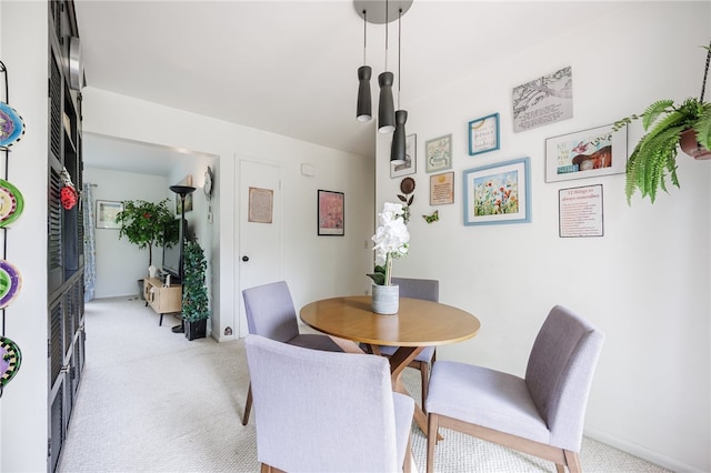 dining room with light carpet and baseboards