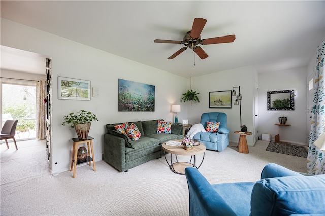 living room featuring light carpet, a ceiling fan, and baseboards