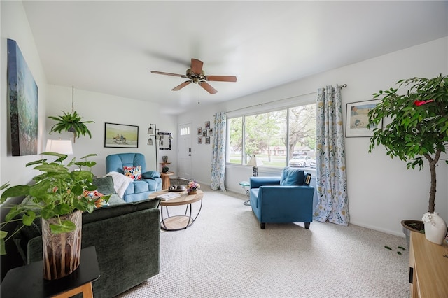 carpeted living area with a ceiling fan and baseboards