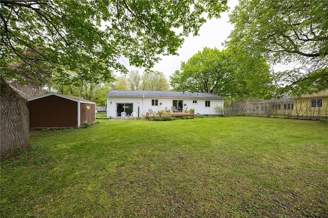 back of property featuring a storage unit, a lawn, an outdoor structure, and a deck
