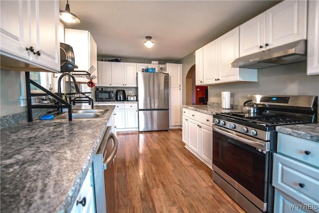 1934 E Middle Rd, Sheridan, NY 14136 - kitchen featuring stainless steel appliances, under cabinet range hood, arched walkways, a sink, and white cabinets