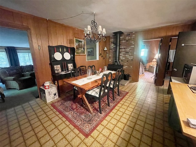 920 New Kingston Rd, Middletown, NY 12455 - dining room featuring a wood stove, wood walls, and a chandelier