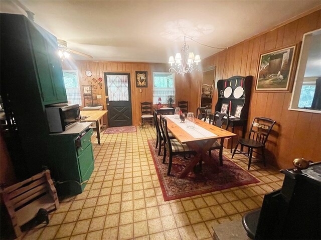 920 New Kingston Rd, Middletown, NY 12455 - dining space with wood walls, a chandelier, light floors, and ceiling fan
