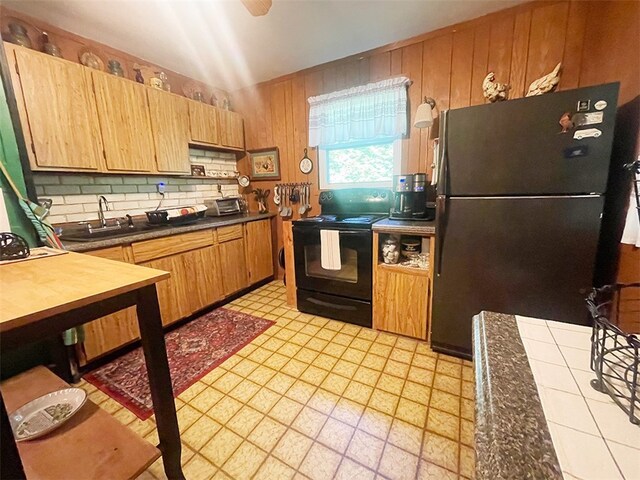 920 New Kingston Rd, Middletown, NY 12455 - kitchen with black appliances, a sink, tasteful backsplash, wood walls, and dark countertops