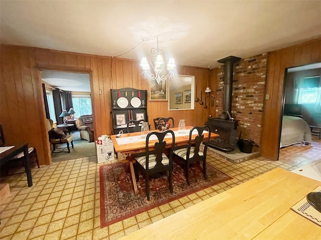 920 New Kingston Rd, Middletown, NY 12455 - dining space featuring wood walls, a chandelier, a wood stove, and tile patterned floors