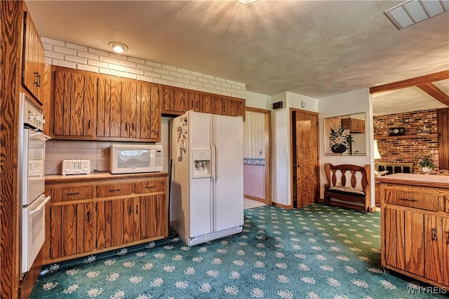 1604 Stardust Ln, Olean-City, NY 14760 - kitchen with white appliances, carpet flooring, brown cabinets, and brick wall