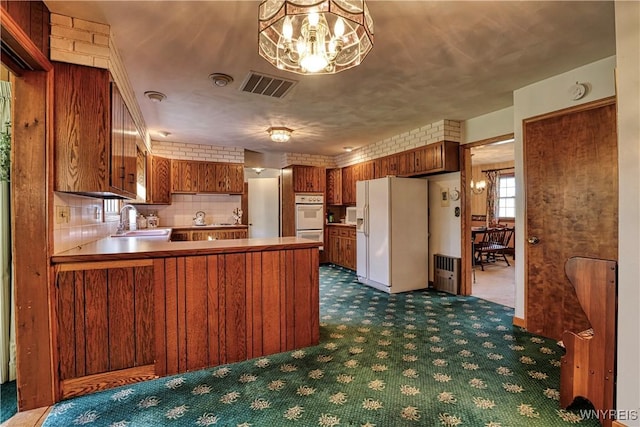 1604 Stardust Ln, Olean-City, NY 14760 - kitchen with white appliances, a sink, dark colored carpet, a chandelier, and brown cabinets