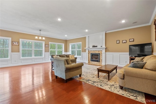 3543 Lost Hollow Rd, Skaneateles, NY 13152 - living area featuring crown molding, a fireplace, a chandelier, a decorative wall, and wood finished floors