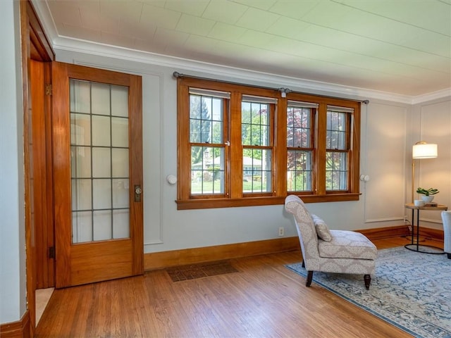 living area featuring ornamental molding, wood finished floors, and baseboards