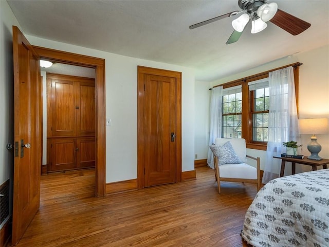 bedroom with wood finished floors, baseboards, and a ceiling fan