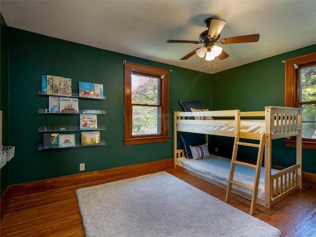 bedroom featuring wood finished floors, baseboards, and a ceiling fan