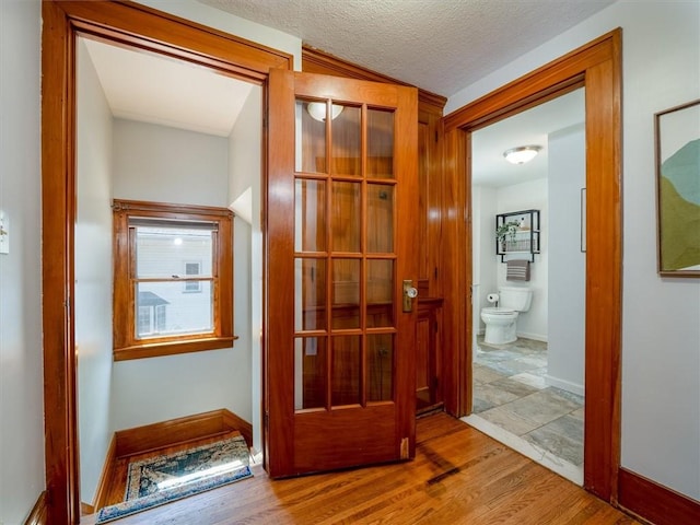 corridor with wood finished floors and baseboards