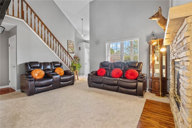 living room with a high ceiling, carpet, stairway, a fireplace, and baseboards