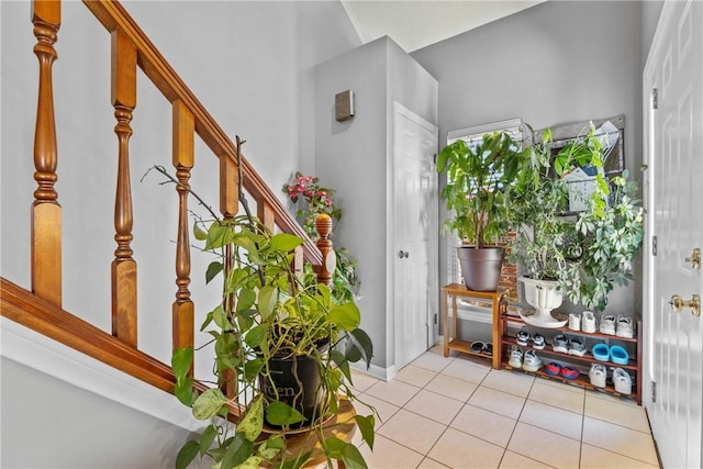 foyer entrance with stairs, tile patterned floors, and baseboards