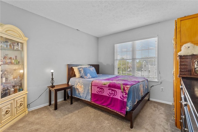 bedroom featuring light colored carpet, a textured ceiling, and baseboards