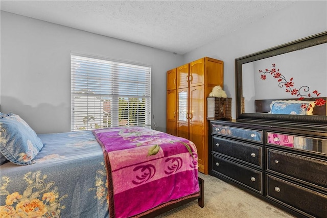 bedroom featuring light carpet and a textured ceiling