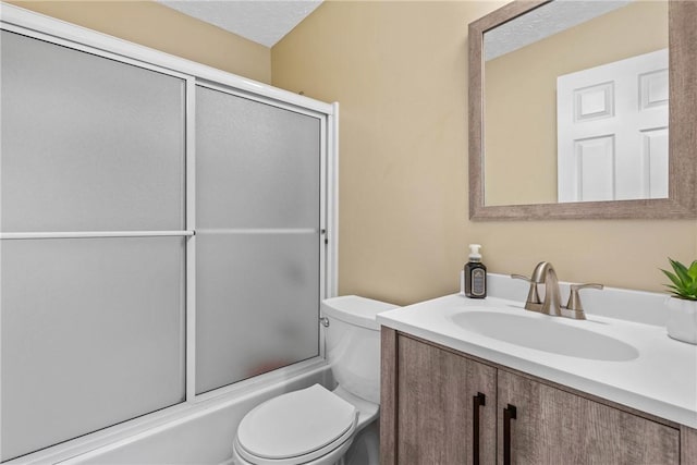 bathroom featuring toilet, vanity, and combined bath / shower with glass door