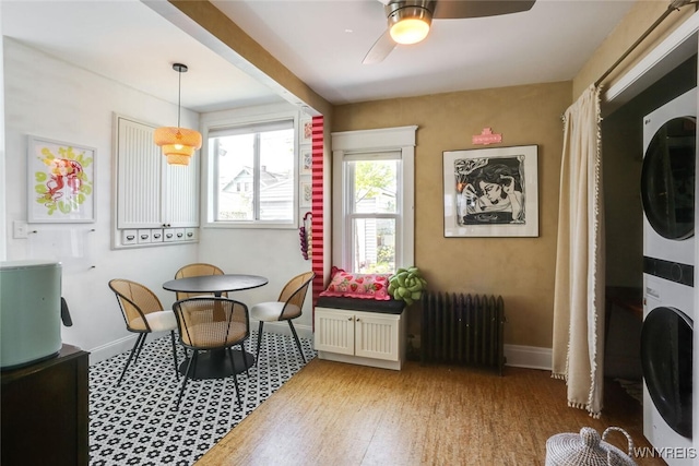 82 Radcliffe Rd, Buffalo, NY 14214 - dining space featuring estacked washer and dryer, radiator heating unit, a ceiling fan, and baseboards