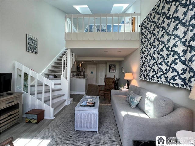 1 Pratt Ave Unit 407, Chautauqua, NY 14722 - living area featuring wood finished floors, a skylight, stairs, and a towering ceiling