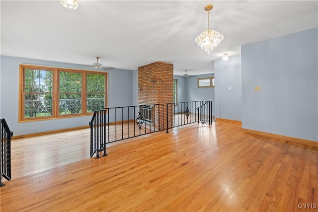7565 Audrey Dr, Clay, NY 13212 - empty room featuring wood finished floors, a chandelier, and baseboards