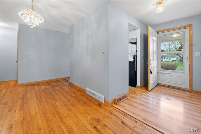 7565 Audrey Dr, Clay, NY 13212 - foyer entrance featuring a chandelier, light wood-type flooring, and baseboards