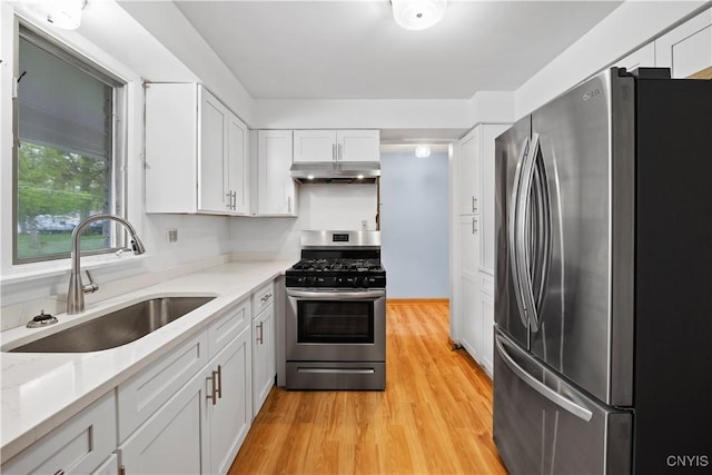7565 Audrey Dr, Clay, NY 13212 - kitchen with stainless steel appliances, a sink, under cabinet range hood, white cabinets, and light wood finished floors