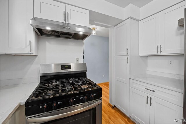 7565 Audrey Dr, Clay, NY 13212 - kitchen featuring stainless steel gas range oven, under cabinet range hood, white cabinetry, light stone countertops, and light wood-type flooring