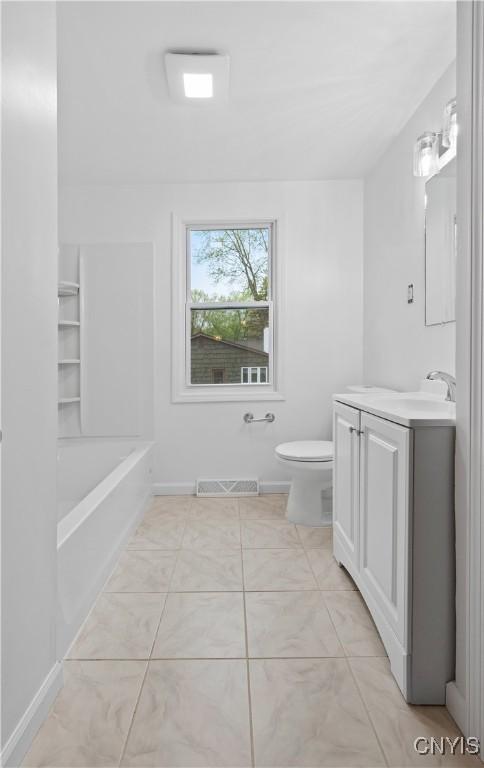 7565 Audrey Dr, Clay, NY 13212 - full bathroom featuring vanity, toilet, a tub, and baseboards