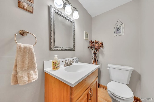 half bath featuring vanity and toilet